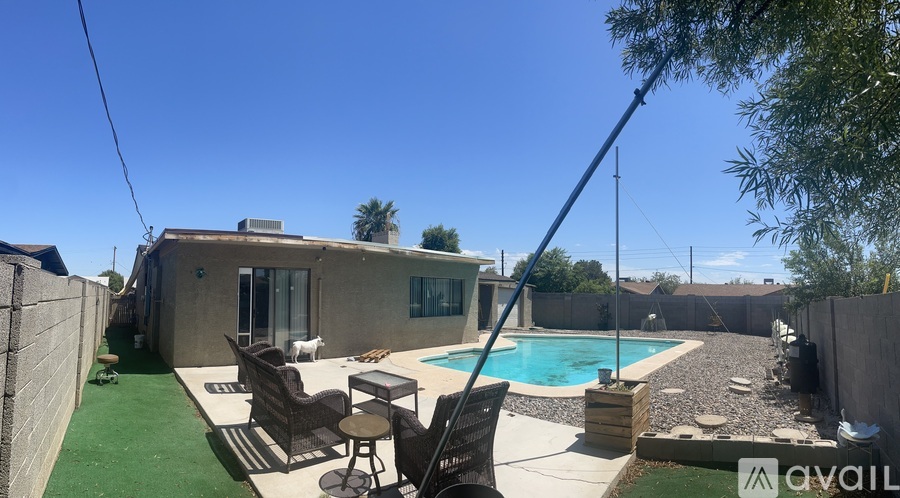 A house with a pool and patio furniture is for sale.