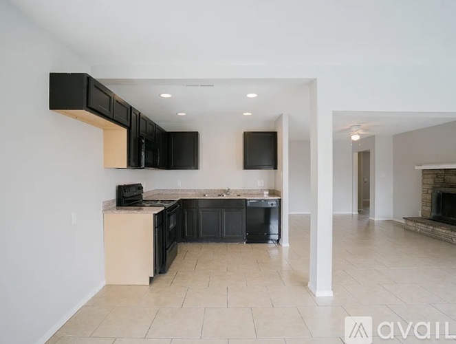 A kitchen with black cabinets and a countertop with a microwave and toaster on it.