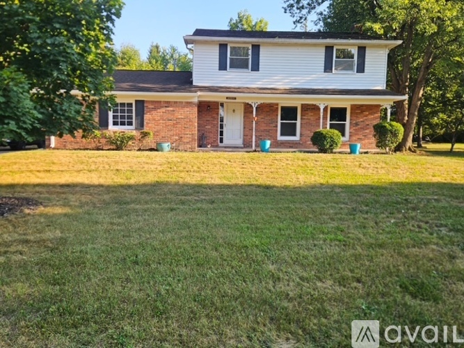 A white house with a brick chimney is for sale.