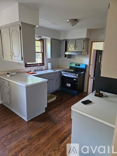 A kitchen with wooden floors and white appliances.
