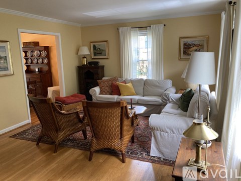 A living room with a white couch and a wooden floor.