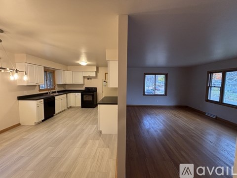 A kitchen with white cabinets and a black countertop is shown.