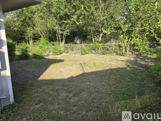 A backyard with a fence and trees.