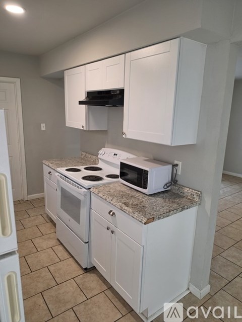 A kitchen with white cabinets and a granite countertop.