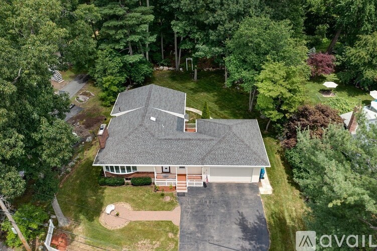 A house with a grey roof surrounded by green trees.