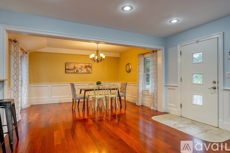 A dining room with a wooden table and chairs.