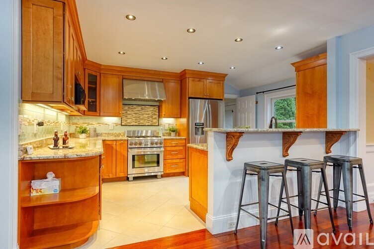 A kitchen with wooden cabinets and a stone backsplash.
