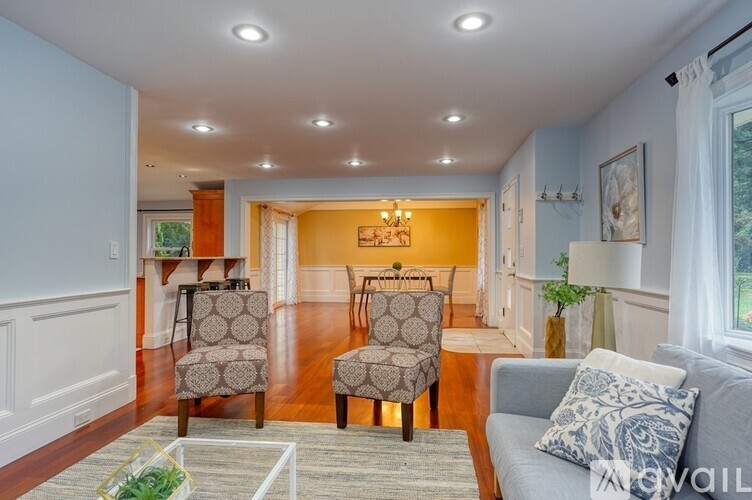 A living room with a grey couch and two patterned chairs.