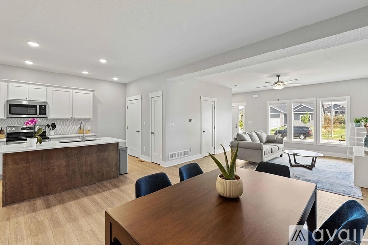 A modern kitchen with a wooden table and chairs in the foreground.