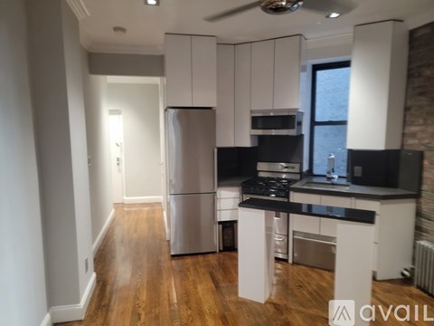 A kitchen with white cabinets and a black countertop.