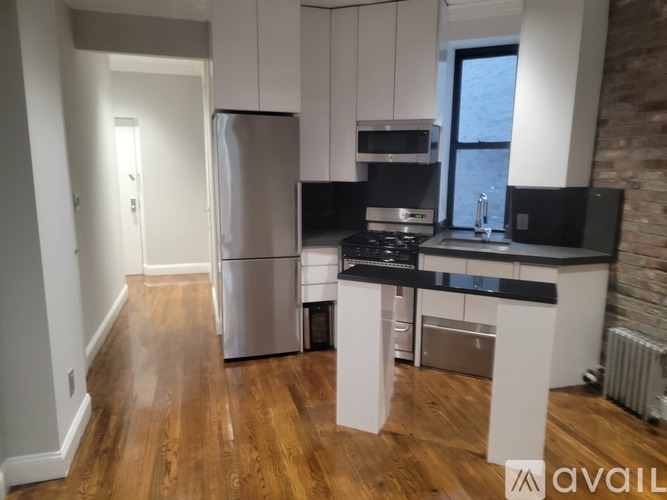 A kitchen with white cabinets and a black countertop.