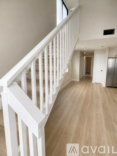 A white staircase with a wooden floor and a logo that reads "avaiL" on the bottom right.