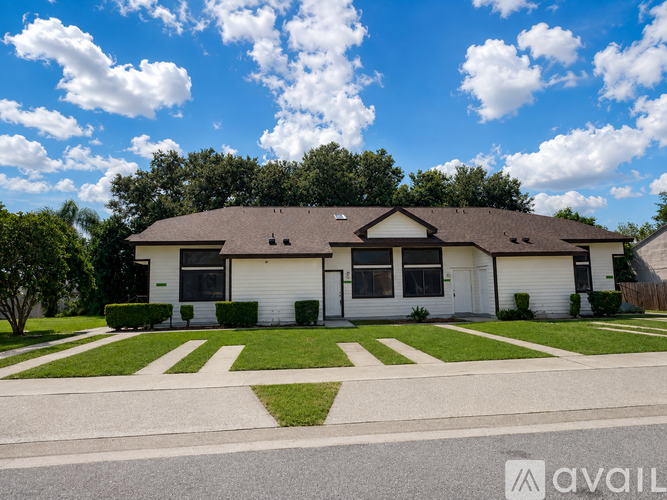 A house with a white exterior and a brown roof is for sale.