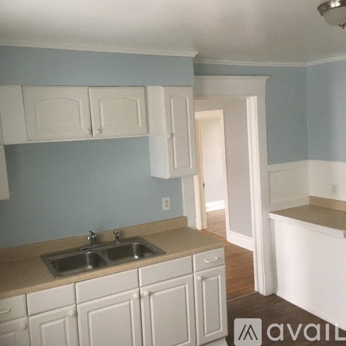 A kitchen with white cabinets and a sink.