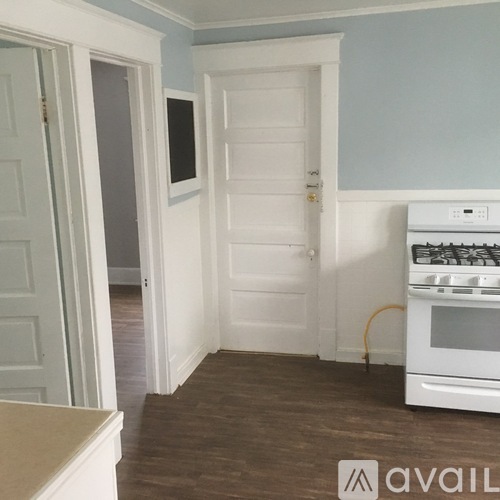 A kitchen with a white oven and white doors.