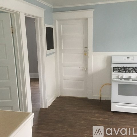 A kitchen with a white oven and white doors.