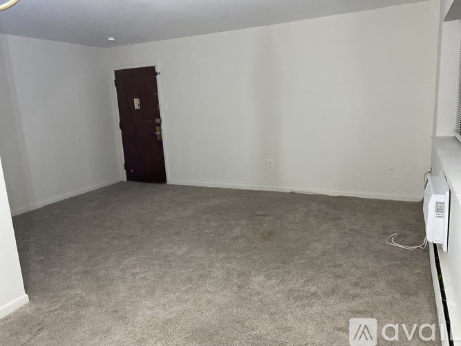 A room with a carpeted floor and a brown door.