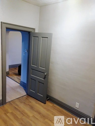 A room with a grey door and a mirror on the wall.