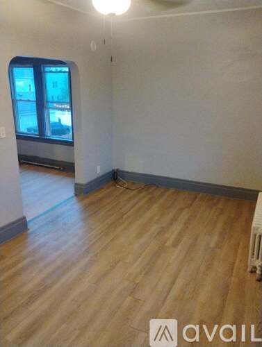 A room with wooden flooring and a window.