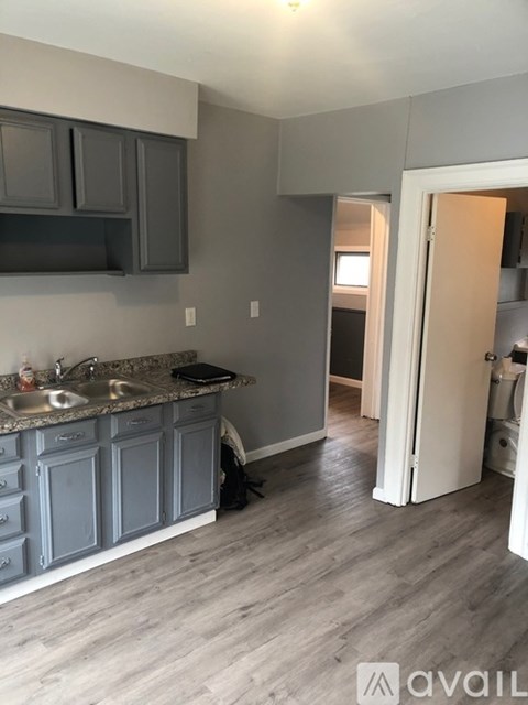 A kitchen with grey cabinets and a sink.
