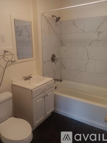 A bathroom with a toilet, sink, and bathtub.