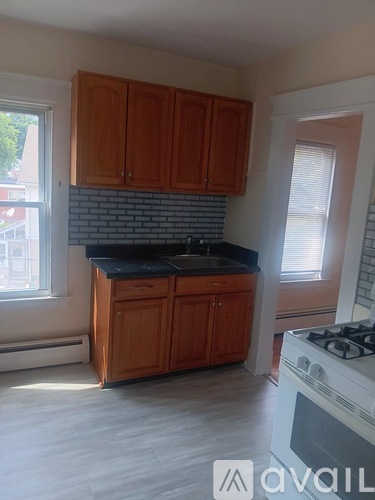 A kitchen with wooden cabinets and a white stove.