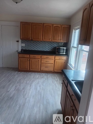 A kitchen with wooden cabinets and a black countertop.
