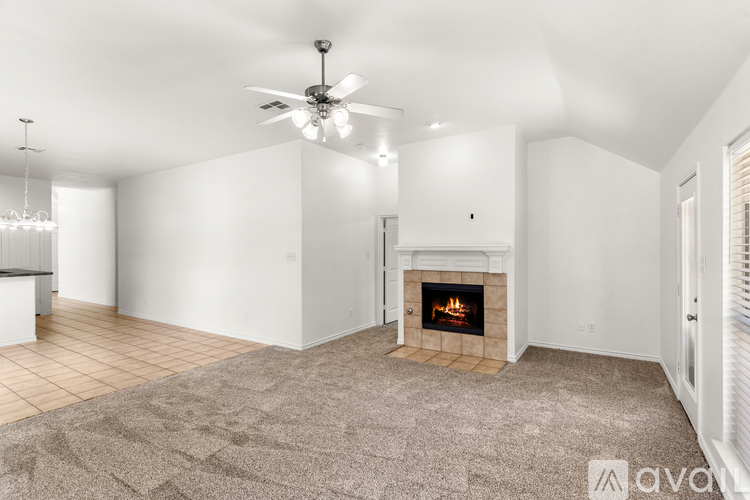 A living room with a fireplace and a ceiling fan.