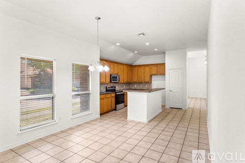 A kitchen with wooden cabinets and a white island.