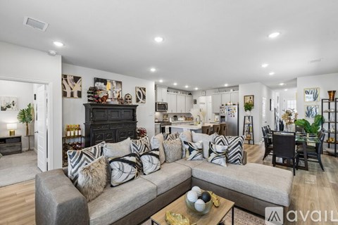 A living room with a grey couch and a fireplace.