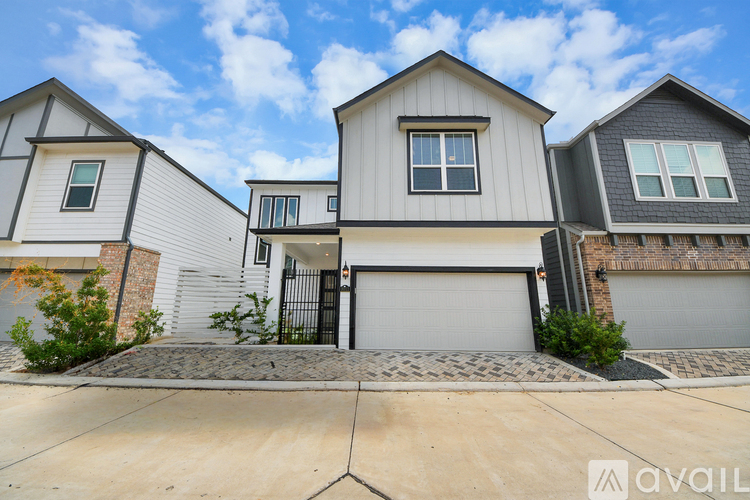 A modern house with a grey garage door is for sale.
