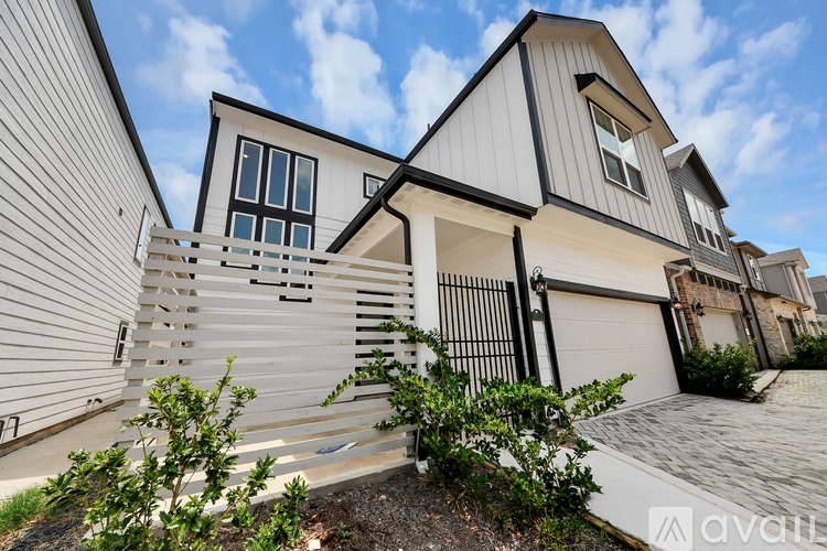 A modern house with a black and white exterior and a large front yard.