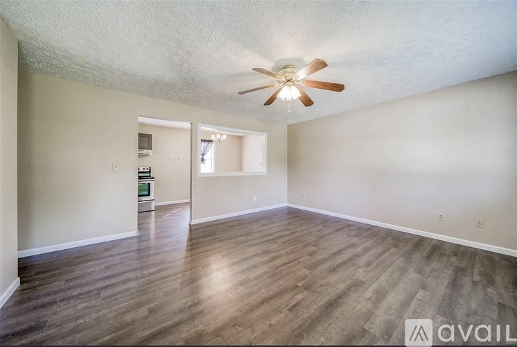 A room with a ceiling fan and wooden flooring.