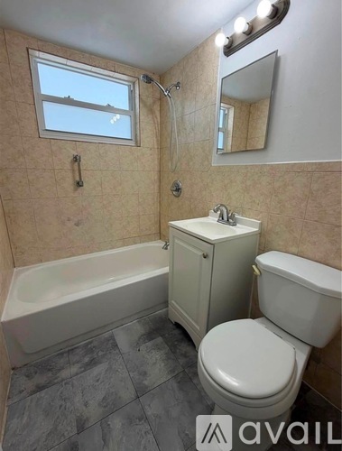 A bathroom with a tub, toilet, and sink.