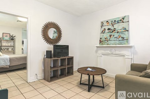 A living room with a brown coffee table and a painting on the wall.