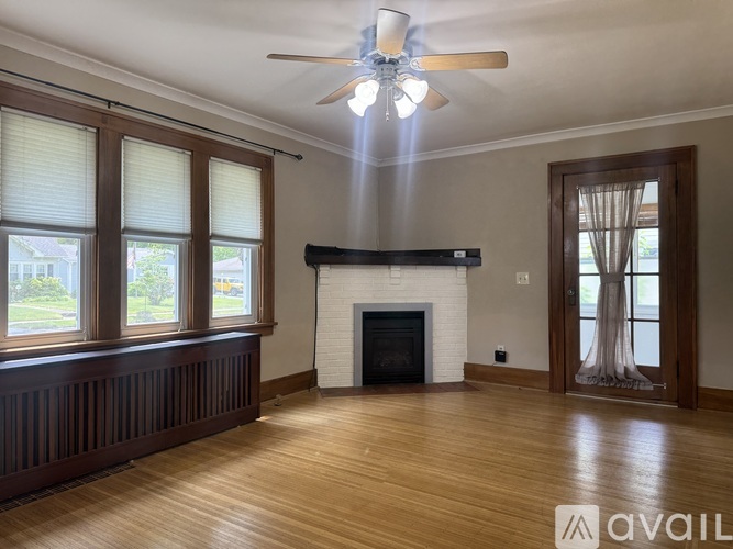 A living room with a fireplace and a ceiling fan.