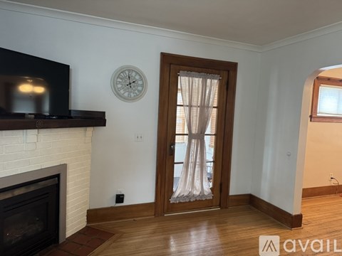 A living room with a fireplace and a television on the wall.