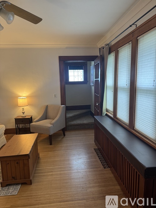 A living room with a wooden floor and a ceiling fan.