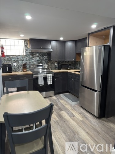 A kitchen with a table and chairs.