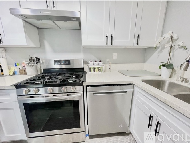 A modern kitchen with white cabinets and stainless steel appliances.