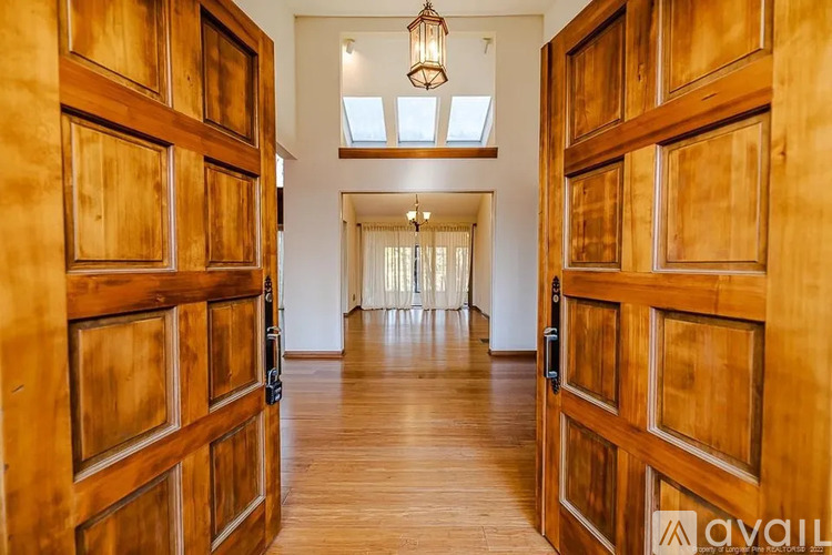 A hallway with wooden doors and a skylight.