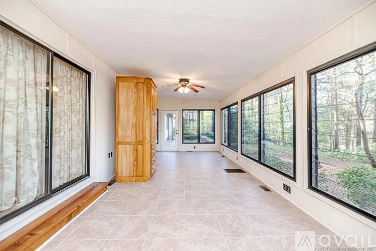 A spacious room with a wooden cabinet and a ceiling fan.