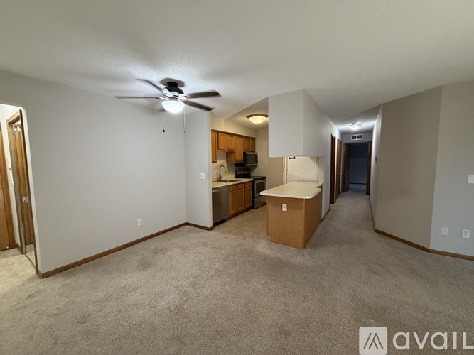 A living room with a ceiling fan and a cabinet.