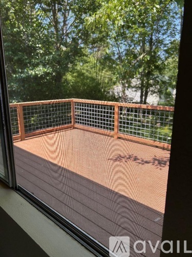 A wooden deck with a metal railing is visible through a window.