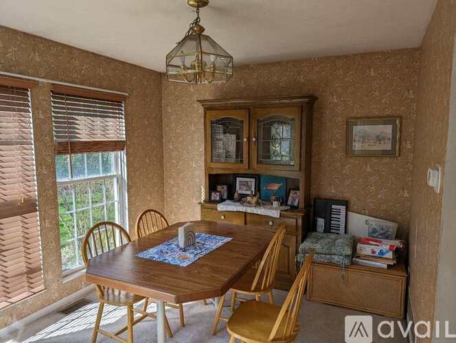 A dining room with a wooden table and chairs.
