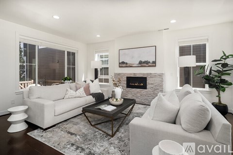 A modern living room with a fireplace and a large painting on the wall.
