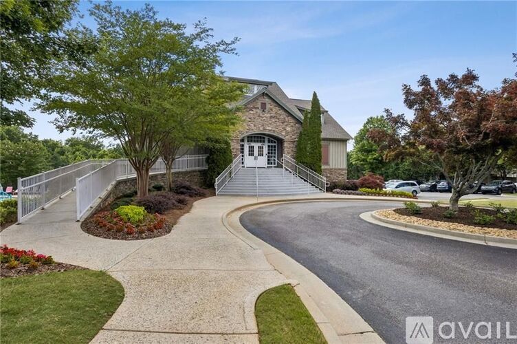 A house with a driveway and a tree in front of it.