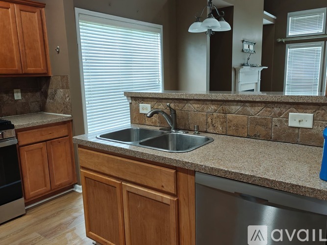 A kitchen with wooden cabinets and a granite countertop.
