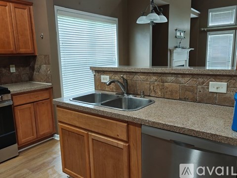 A kitchen with wooden cabinets and a granite countertop.
