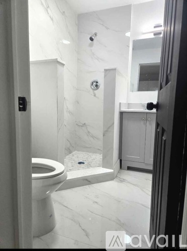 A white toilet in a bathroom with marble floors and walls.